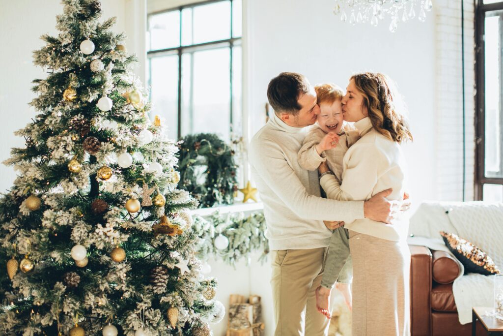 A joyful family embraces near a beautifully decorated Christmas tree during the festive season.